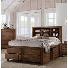 a bed sitting in a bedroom next to a dresser and drawers on top of a wooden floor