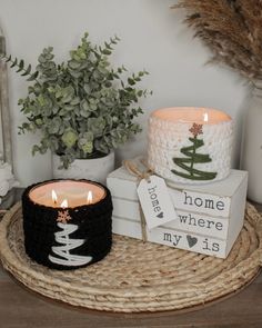 two candles on a wicker tray next to some christmas decorations and other holiday items