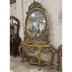 an ornately decorated gold vanity with mirror on the top and two mirrors behind it