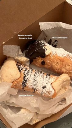 an open box containing two pastries and some sort of chocolate covered doughnuts