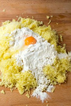 a wooden cutting board topped with cheese and an egg on top of it's flour