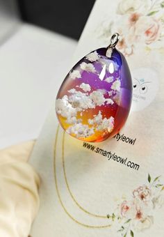 a glass pendant with clouds on it