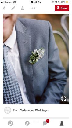 a man wearing a suit and tie with a boutonniere on his lapel