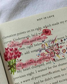 an open book with watercolors and writing on the pages in pink, red and blue