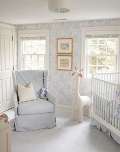 a baby's room with blue and white wallpaper