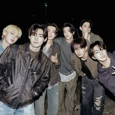 a group of young men standing next to each other in front of a street light