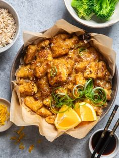 a bowl filled with food next to bowls of rice and broccoli