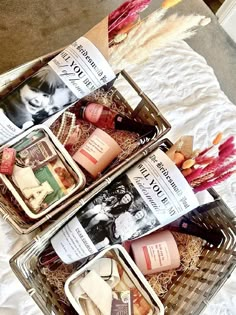 two baskets filled with different types of items on top of a white sheet covered bed