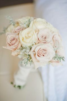 a bridal holding a bouquet of white and pink roses