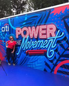 two people are standing in front of a sign that says power to the movement on it