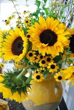 a vase filled with lots of yellow sunflowers