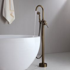 a white bath tub sitting under a faucet next to a wall mounted shower head