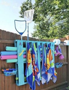 there is a rack with towels hanging on the fence and other items in front of it