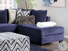 a living room with a blue couch and ottoman