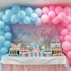 a table topped with lots of balloons and desserts next to a sign that says boy or girl