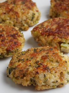 four crab cakes are arranged on a white plate