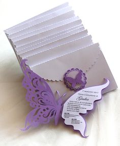 a close up of a folded card with a butterfly on the front and some tags attached to it