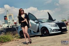 a woman is standing next to a car