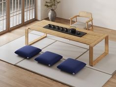 a table with three stools in front of it on a rug next to a window