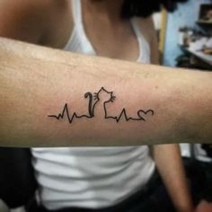 a person with a tattoo on their arm that has heartbeats and an arrow in the shape of a cat