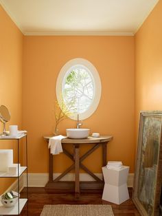 a bathroom with orange walls and wooden floors