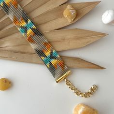 the beaded bracelet is next to shells and seashells on a white surface