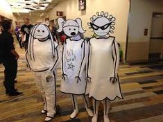 three people dressed up as cartoon characters standing in an office hallway with other people behind them