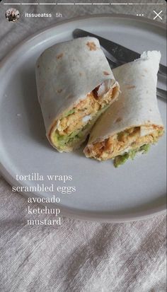 two burritos on a plate with a fork and knife