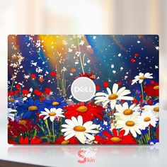 a laptop computer sitting on top of a white table covered in colorful flowers and butterflies