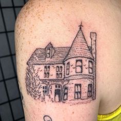 a black and white photo of a house on the back of a woman's shoulder