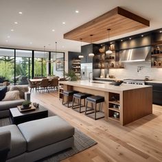 an open concept kitchen and living room with wood flooring, modern furniture and large windows