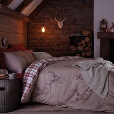 a bed in a room with brick walls and a fireplace next to it is made up