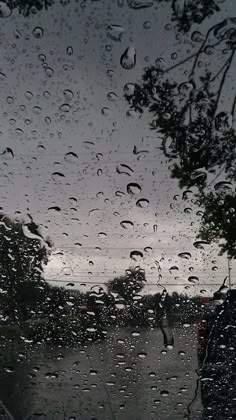 rain is falling down on the windshield of a car