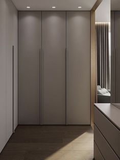 an empty room with white cabinets and lights on the ceiling, along with a large mirror