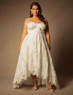 a woman in a white dress posing for the camera with her hands on her hips