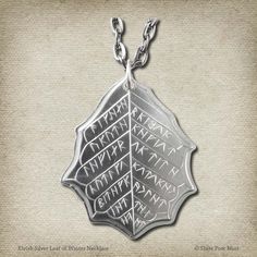 A Silver Winter Leaf of HOLLIN™ Also known as Eregion (meaning Land of the Holly in Sindarin), Hollin was an Elven Realm of the Ñoldorin Elves during the Second Age. It was located near the West Gate of Moria, or Khazad-dûm. These coins were made by the Ñoldorin Elves while under the rule of Celebrimbor, the great Elven-smith and forger of the Rings of Power. Hollin was later destroyed during the War of the Elves and Sauron.The Tengwar side translates from Sindarin: “Star-kindler, O Elbereth! Wh West Gate, Winter Necklace, Winter Leaves, Power Ring, Bow Bracelet, Black Flag, Ring Pendant Necklace, Leaf Necklace, Silver Gifts