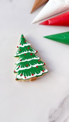 three decorated christmas trees sitting on top of a white counter next to candy canes