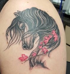 a woman with a horse tattoo on her arm and shoulder, holding flowers in her hand