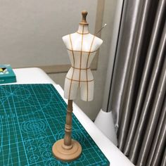 a mannequin is standing on top of a cutting board with a sewing machine next to it