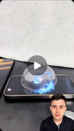 a man standing in front of a cell phone with a blue flame coming out of it