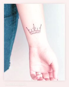 a woman's arm with a crown tattoo on it