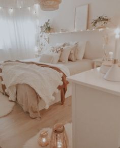 a bed room with a neatly made bed next to a night stand and two candles