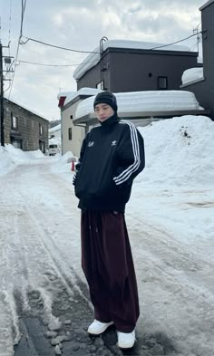 a person standing in the middle of a snowy street