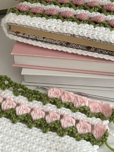 three crocheted book ends sitting next to each other on top of a pile of books