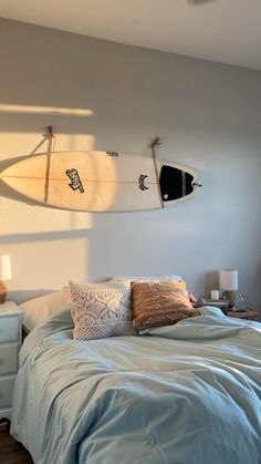 two surfboards hanging on the wall above a bed