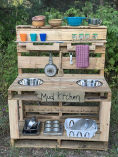 an outdoor kitchen made out of wooden pallets with pots and pans on it