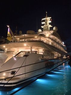 a large white boat docked in the water at night with lights on it's hulls