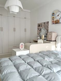 a bedroom with white furniture and gray bedding