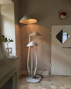 a lamp that is on top of a stand in the middle of a room next to a door