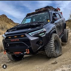 a black toyota truck driving down a dirt road